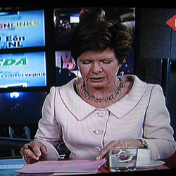 On se demandait ce qu'était devenue la speakerine de l'URSS. Elle présente les élections en Ruritanie. // One wondered what the Soviet TV-anchorette had become. She hosts the Ruritanian elections program.